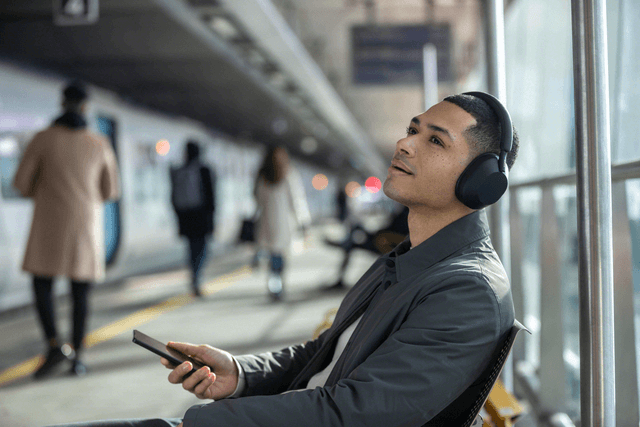 Mies kuuntelee musiikkia Sony XM5-kuulokkeilla joissa ensiluokkainen vastamelu