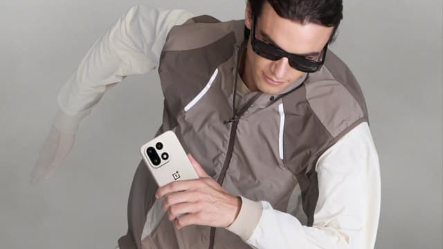 Treenivaatteisiin pukeutunut mies lähdössä juoksuun OnePlus 15 -puhelin kädessään