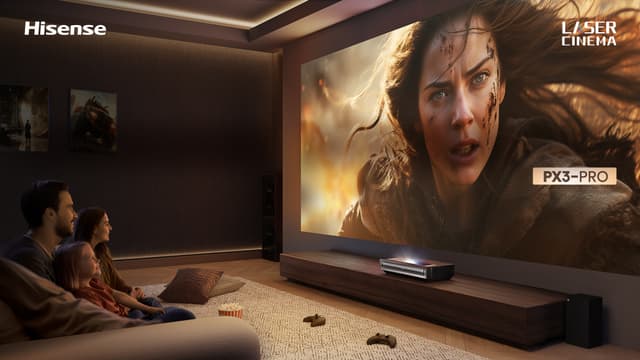 Perhe on kerääntynyt olohuoneeseen katsomaan elokuvaa Hisense PX3 Pro -projektorilta