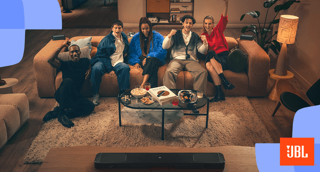 Ystäväporukka katselee televisiota yhdessä JBL-huippuäänentoistolla