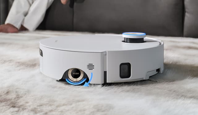 Hvit robotstøvsuger rengjør mykt teppe