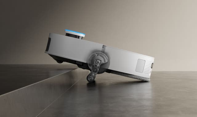 Robotstøvsugeren Dreame X50 Ultra klatrer over terskel med sine uttrekkbare armer
