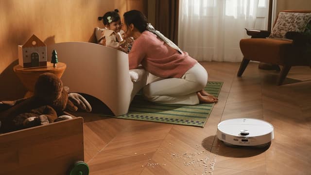 Roborock Qrevo Edge 2 Pro støvsuger smuler på barnerom mens mor og barn leker