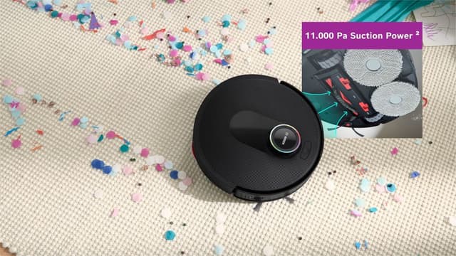 Bosch Max Cam robotdammsugare på en matta täckt med konfetti, med en infälld bild som visar undersidan och sugkraften.