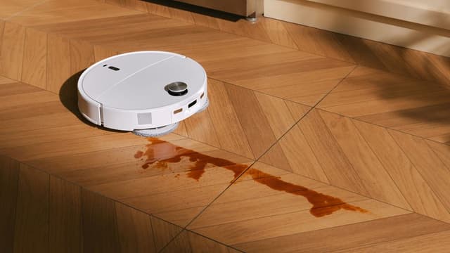 Roborock Qrevo Edge 2 Pro använder sina dubbla roterande moppar för att ta bort kaffefläckar på ett laminatgolv.
