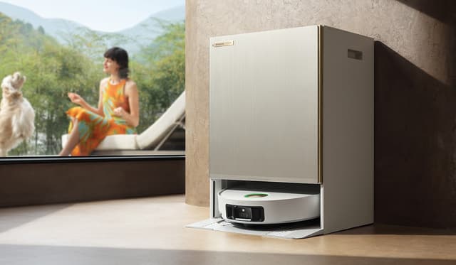 Dreame Matrix10 Ultra i sin alt-i-én Powerdock mens kvinde leger med sin hund i baggrunden