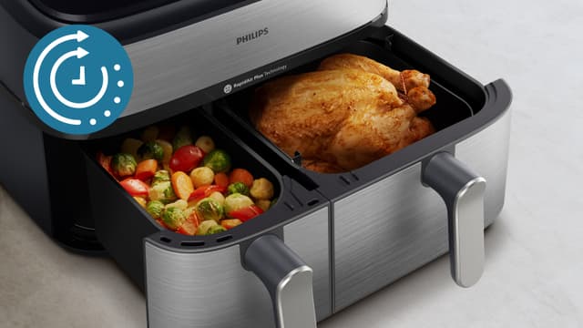 Åpen Philips airfryer med kylling og grønnsaker i hver sin kurv
