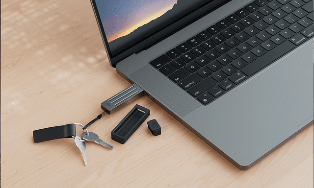 Laptop med tilkoblet USB på et skrivebord i tre