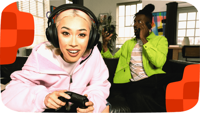 Kvinde gamer, mens en mand ved siden af hende taler i telefon