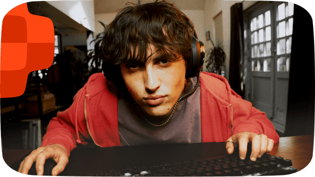 Nuori pelaaja JBL Quantum -pelikuulokkeet päässään