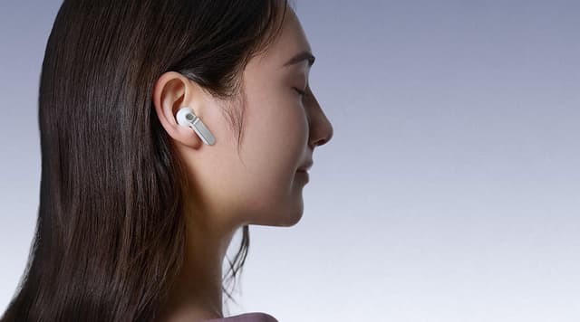 Kvinna i profil som bär sina Samsung Galaxy Buds4 hörlurar.