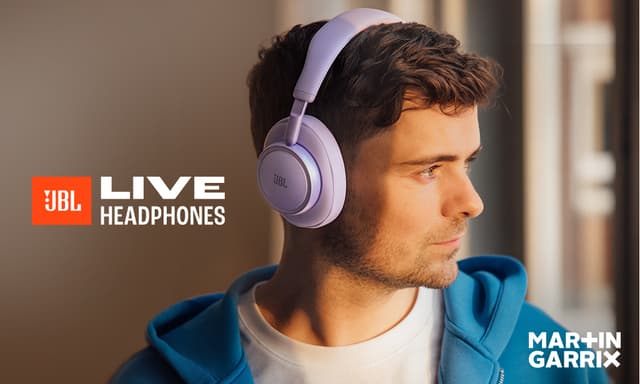 Produktbanner med bilde av en ung mann med lilla JBL Live 780 støydempende hodetelefoner som ser ut av et vindu.