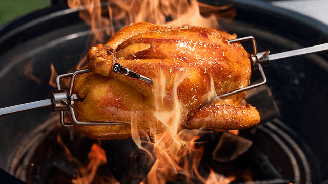 En hel kylling steker over en grill med flammer, tilkoblet et Typhur Sync Dual-termometer.