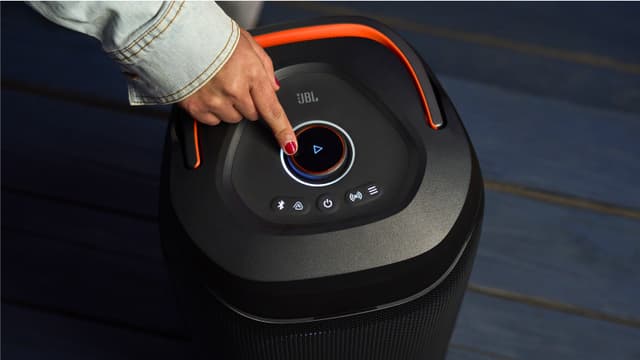 Person tænder JBL PartyBox 130 højttaler på knap