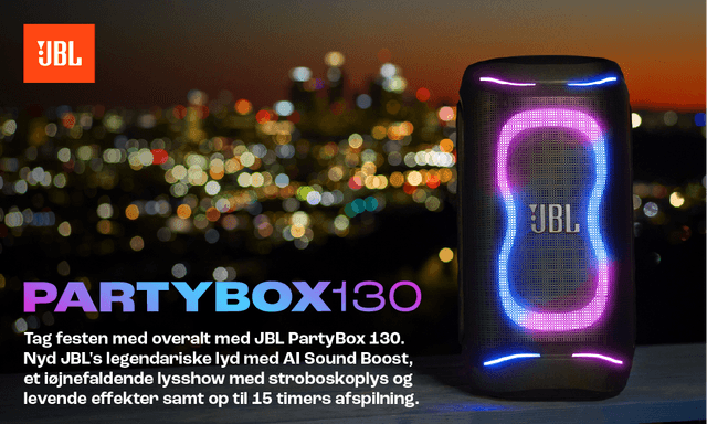 En JBL PartyBox 130‑højttaler i mørke med levende lyseffekter foran en panoramisk bysilhuet