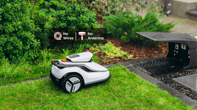 En Terramow V1000-robotgressklipper kjører inn i garasjen sin mens det regner.