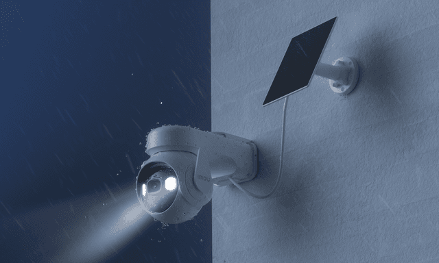 IMOU Cell PT Lite placeret udenfor i mørke og regn med sine spotlights tændt