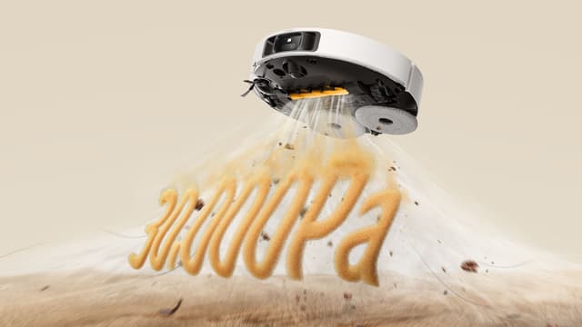 Illustrasjon av en Dreame L50s Pro Ultra-rengjøringsrobot som svever i lufta og suger opp støv, sand og smuler.
