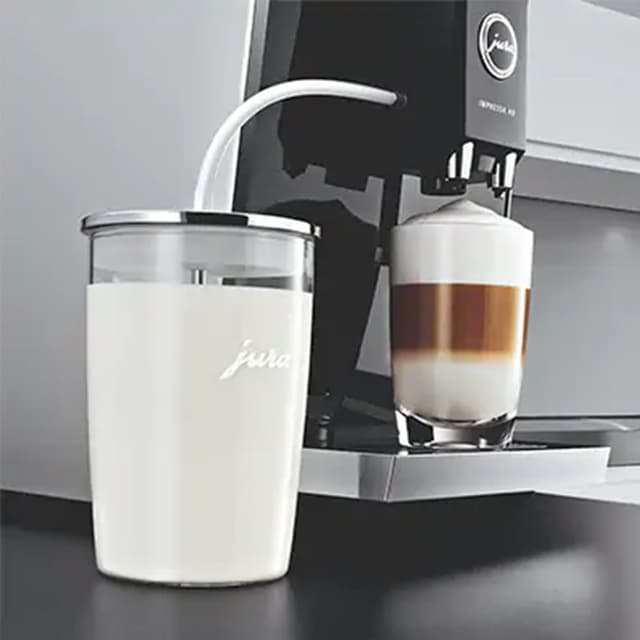 En Jura-kaffemaskin tilbereder en cappuccino med melkeskummeren sin.