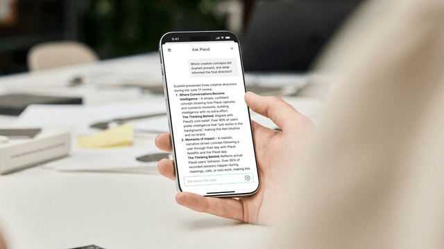 En hånd som holder en smarttelefon og skjermen som viser en brukers samtale med Plaud.