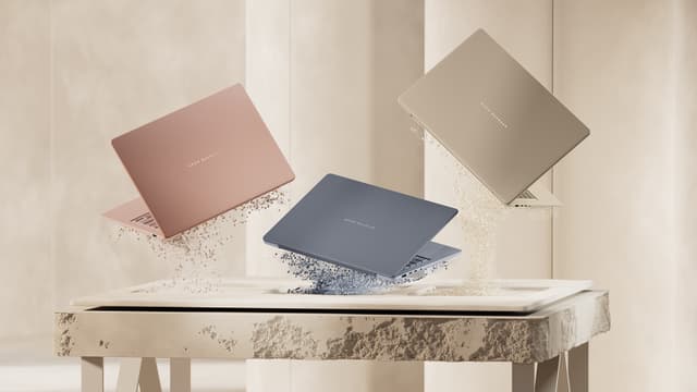 Tre ASUS Zenbook 14 UX3480 i ulike farger på et marmorbord med en beige bakgrunn.