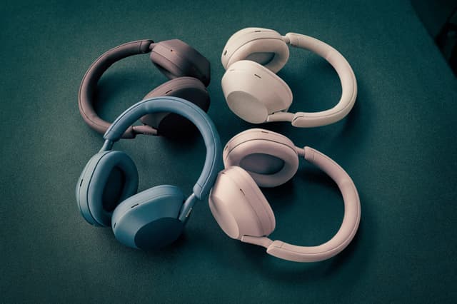 Eri värisiä Sony XM5 -kuulokkeita aseteltuna ympyrän muotoon