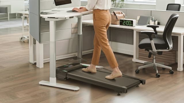 Woman walks on her Urevo Spacewalk 5L walking pad while working