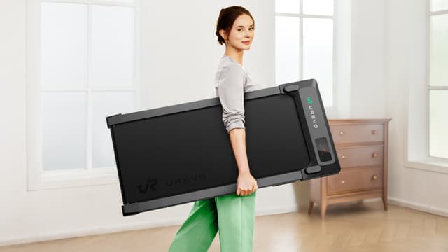 Woman carrying a portable and compact Urevo Spacewalk E1L walking pad