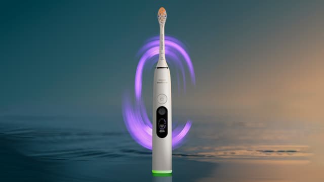 Philips Sonicare DiamondClean elektrisk tannbørste med hav og lilla lys i bakgrunnen.