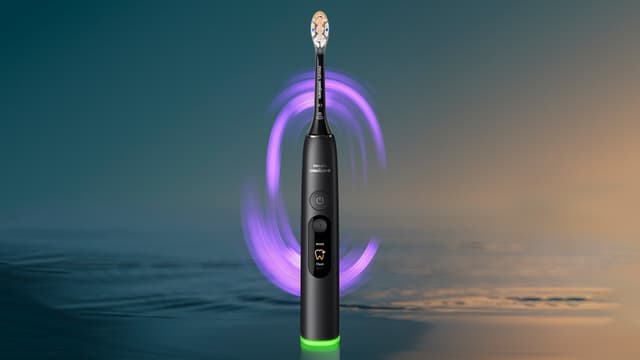 Philips Sonicare DiamondClean elektrisk tannbørste med hav og lilla lys i bakgrunnen.