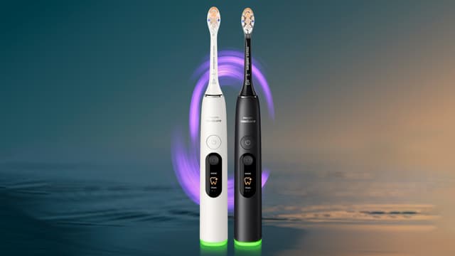 En sort og en hvid Philips Sonicare DiamondClean elektrisk tandbørste med vand og lilla lys i baggrunden