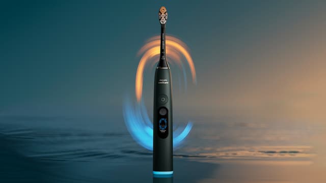 Black Philips Sonicare DiamondClean electric toothbrush with water and blue and yellow light in the background