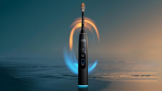 Sort Philips Sonicare DiamondClean elektrisk tandbørste med vand samt blåt og gult lys i baggrunden