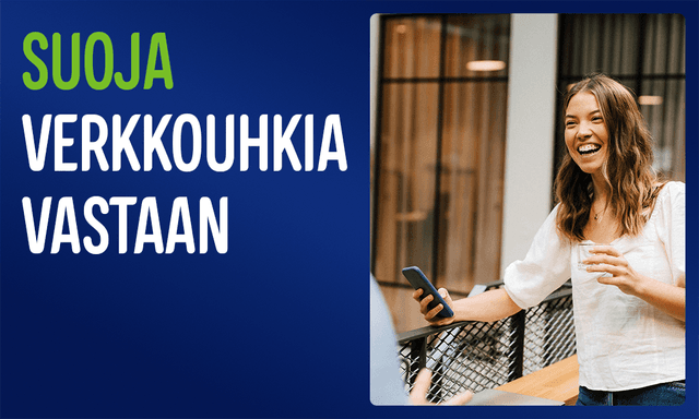 Hymyilevä nainen seisoo yrityksen käytävällä puhelin kädessään, sekä teksti; Suoja verkkouhkia vastaan