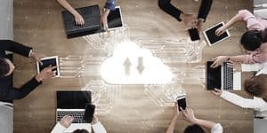 Multiple people around a table using cloud storage to work together