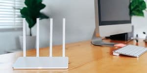 Moderne Wi-Fi-router på et lyst bord på hjemmekontoret