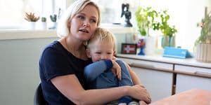 Äiti ja lapsi istuvat pöydän ääressä