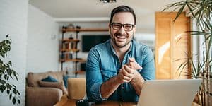 Smilende mann foran PC-en