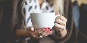 Nærbillede af kvinde, der holder en stor kop kaffe