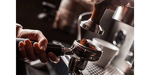 Hånd holder filterholder full av malt kaffe
