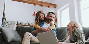 Iloinen perhe tietokoneen ääressä