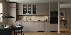 Epoq Trend Sand kjøkken i en åpen kjøkkenløsning med integert stekeovn, vitrineskap og spisebord