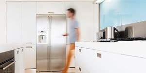 En mann lener seg inntil en kjøkkenbenk