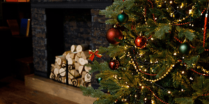 Dekorert juletre foran peisen