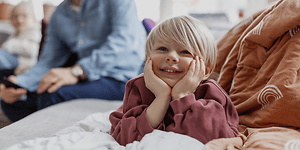 5 tips när du ska köpa ny TV:  Glad unge och hans familj i bakgrunden.