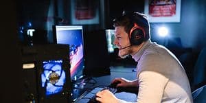 Mand, der spiller på gaming-PC, og som har et HyperX gaming-headset på hovedet