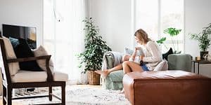Woman and baby sitting on a couch in the living room