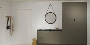 Epoq Trend Moss Green -sarjan kaapeilla varustettu kodinhoitohuone, musta työtaso, jonka ylle on ripustettu pyöreä peili