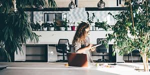 Kvinde der arbejder på et kontor omgivet af planter