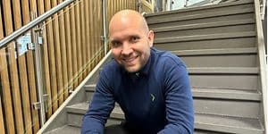 Mig-tid - Ambassadør Christian i blå Elgiganten-skjorte på en trappe